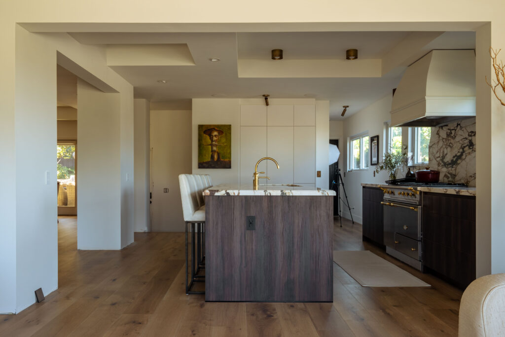 Framed opening with exposed beam creating seamless open kitchen layout