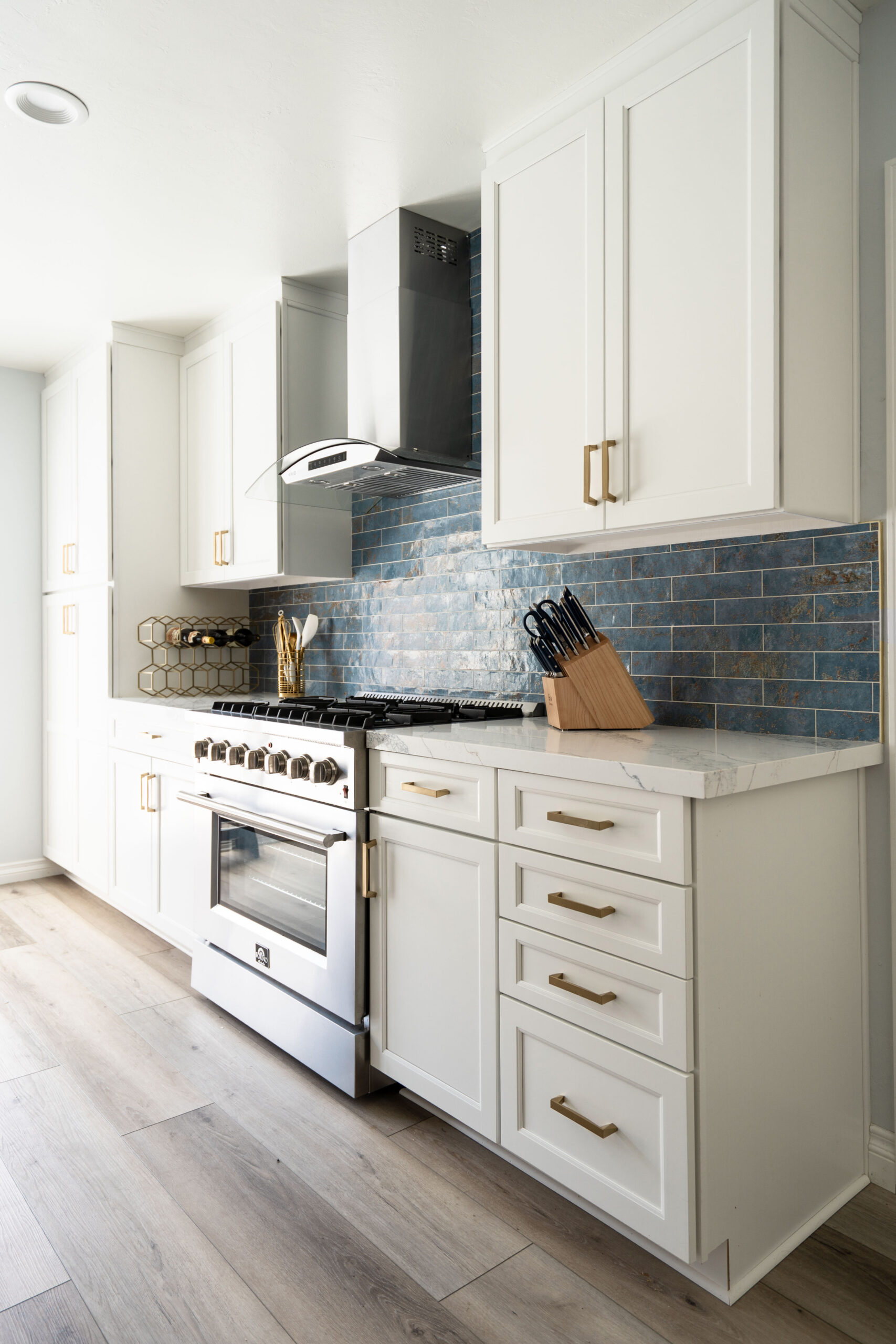 San Diego Kitchen Remodel, blue-coastal Clairemont, San Diego kitchen renovation with white shaker cabinets, gold hardware, stainless steel range, and coastal blue backsplash.